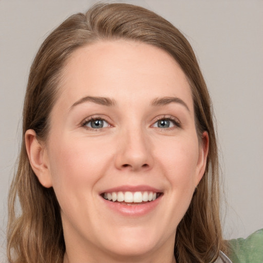 Joyful white young-adult female with long  brown hair and grey eyes