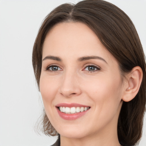 Joyful white young-adult female with medium  brown hair and grey eyes