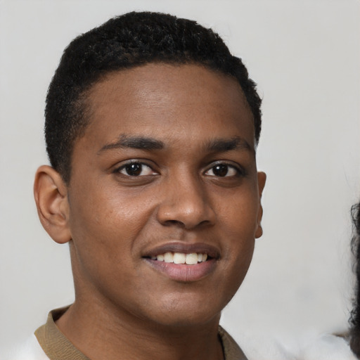 Joyful black young-adult male with short  black hair and brown eyes