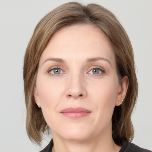 Joyful white adult female with medium  brown hair and grey eyes