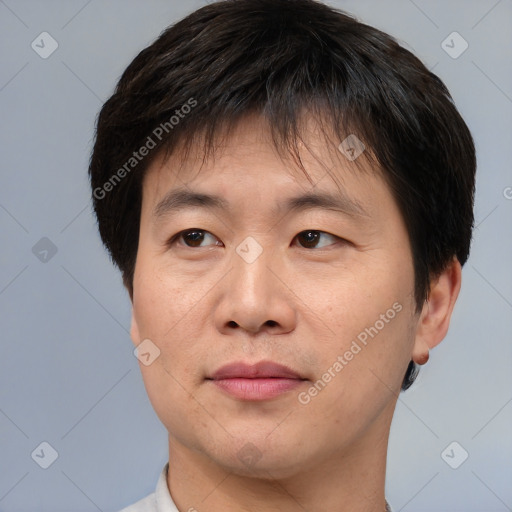 Joyful asian adult male with short  brown hair and brown eyes