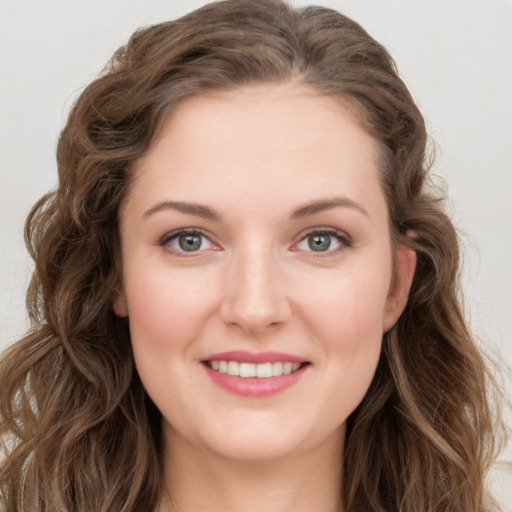 Joyful white young-adult female with long  brown hair and blue eyes