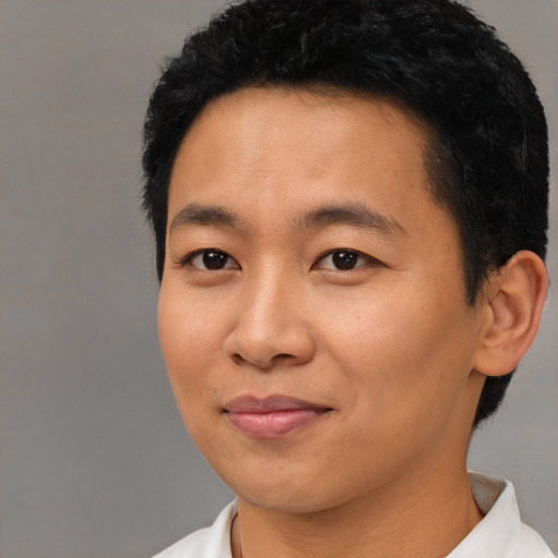 Joyful asian young-adult male with short  black hair and brown eyes