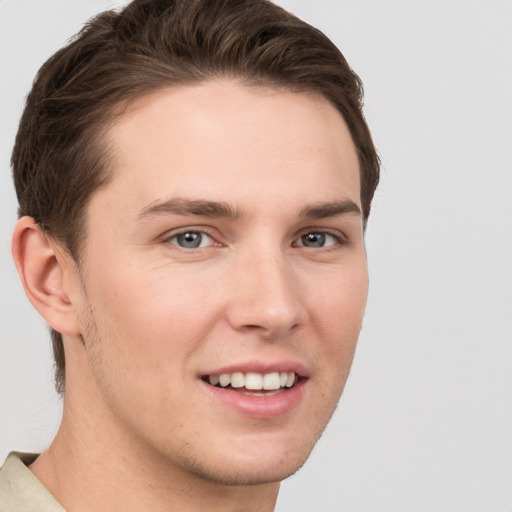 Joyful white young-adult male with short  brown hair and grey eyes