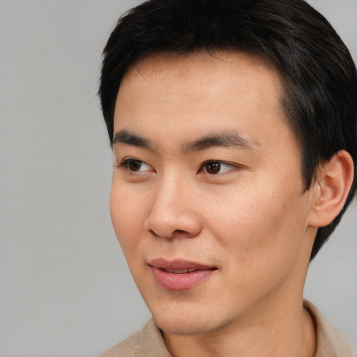 Joyful asian young-adult male with short  black hair and brown eyes