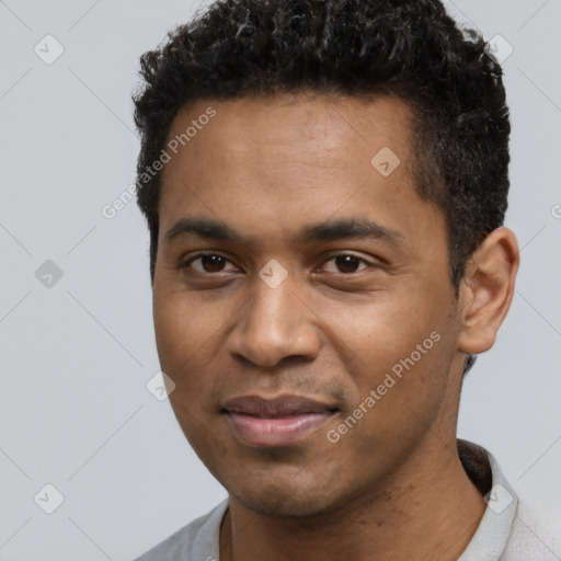 Joyful black young-adult male with short  black hair and brown eyes