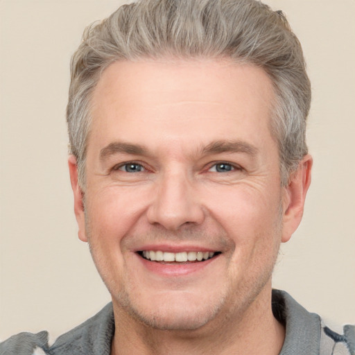 Joyful white adult male with short  brown hair and grey eyes