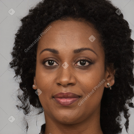 Joyful black young-adult female with long  brown hair and brown eyes