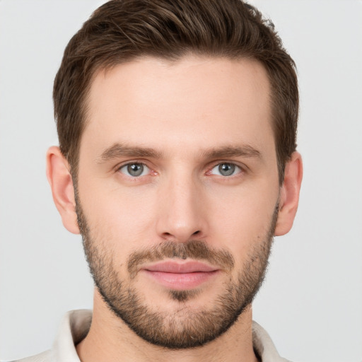 Joyful white young-adult male with short  brown hair and grey eyes