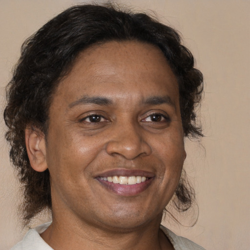 Joyful black adult male with short  brown hair and brown eyes
