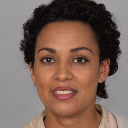 Joyful black young-adult female with short  brown hair and brown eyes