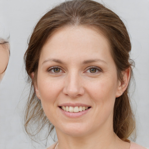 Joyful white young-adult female with medium  brown hair and grey eyes