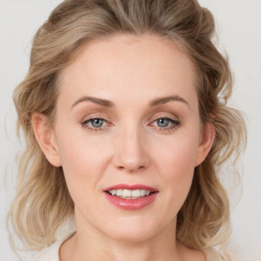 Joyful white young-adult female with medium  brown hair and blue eyes