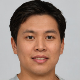 Joyful asian young-adult male with short  brown hair and brown eyes