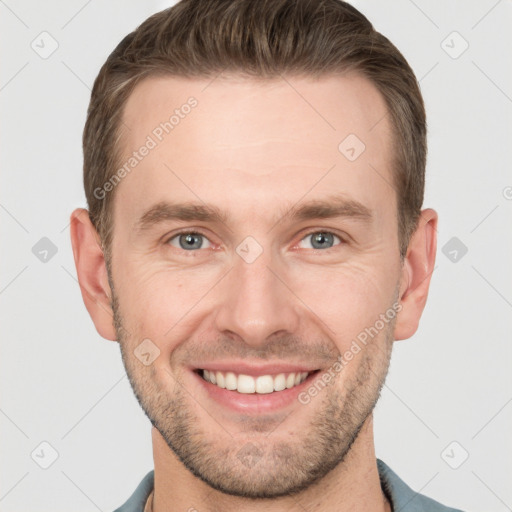 Joyful white young-adult male with short  brown hair and grey eyes