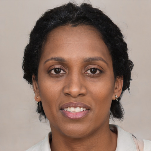 Joyful black adult female with short  black hair and brown eyes
