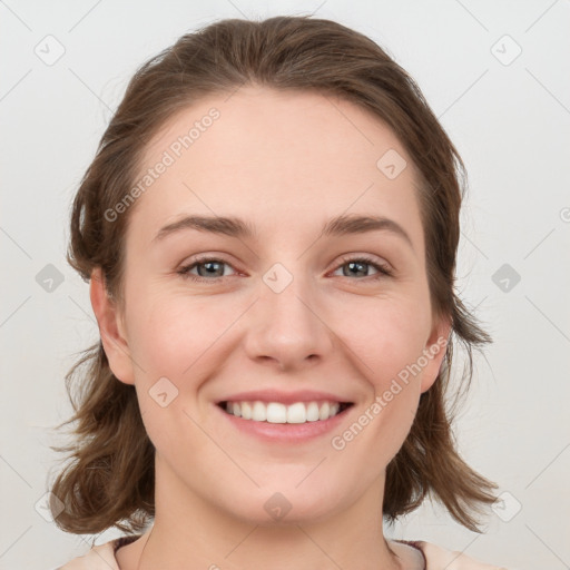 Joyful white young-adult female with medium  brown hair and grey eyes