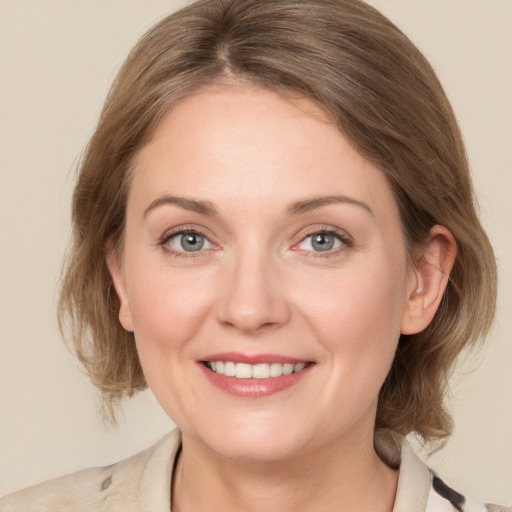 Joyful white adult female with medium  brown hair and blue eyes