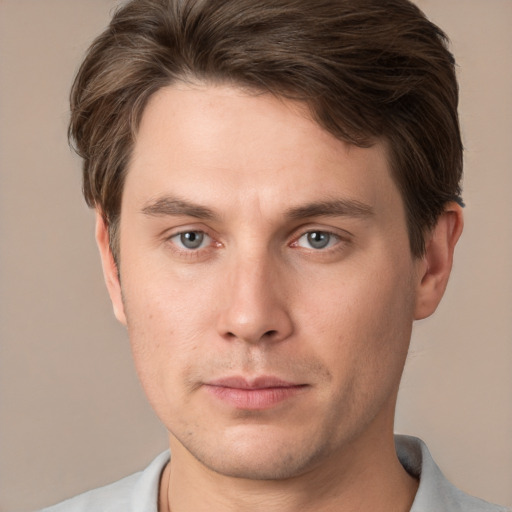 Joyful white young-adult male with short  brown hair and grey eyes