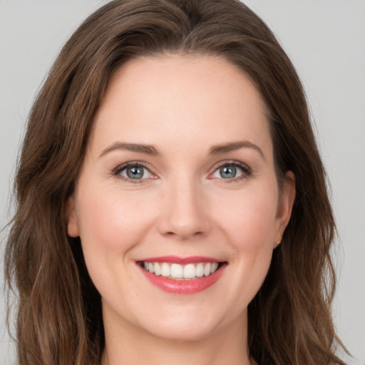 Joyful white young-adult female with long  brown hair and grey eyes