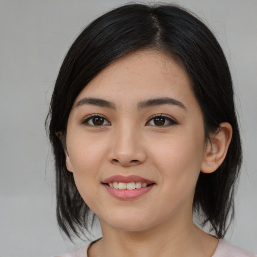 Joyful asian young-adult female with medium  black hair and brown eyes