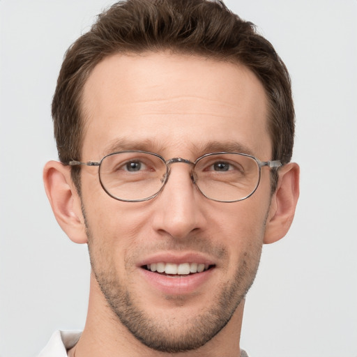 Joyful white adult male with short  brown hair and grey eyes