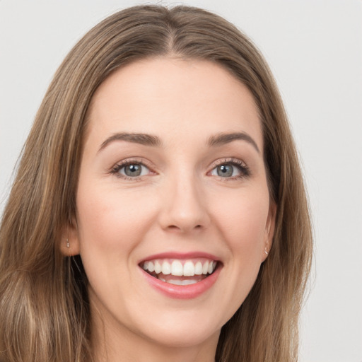 Joyful white young-adult female with long  brown hair and green eyes