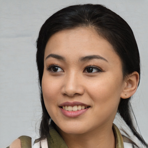Joyful latino young-adult female with medium  brown hair and brown eyes