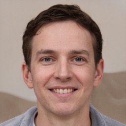 Joyful white adult male with short  brown hair and grey eyes