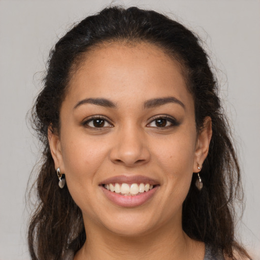 Joyful latino young-adult female with long  brown hair and brown eyes