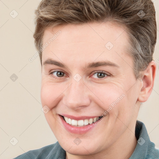 Joyful white young-adult male with short  brown hair and grey eyes