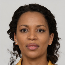 Joyful black young-adult female with medium  brown hair and brown eyes