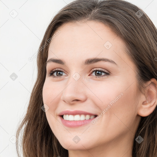 Joyful white young-adult female with long  brown hair and grey eyes