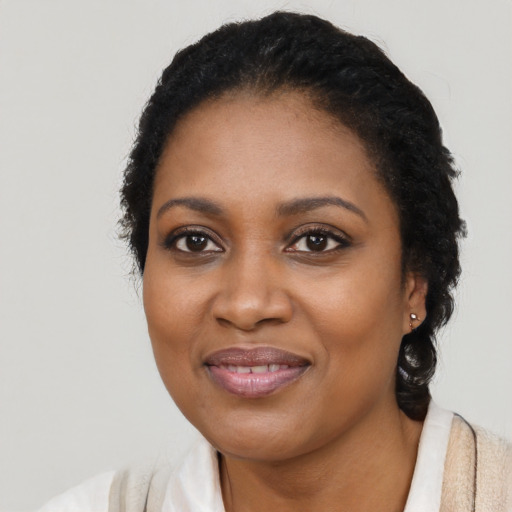 Joyful black young-adult female with short  black hair and brown eyes