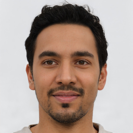 Joyful latino young-adult male with short  black hair and brown eyes