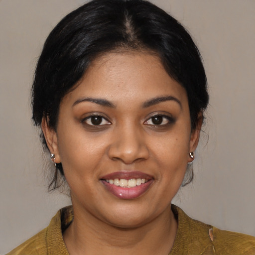 Joyful black young-adult female with medium  black hair and brown eyes