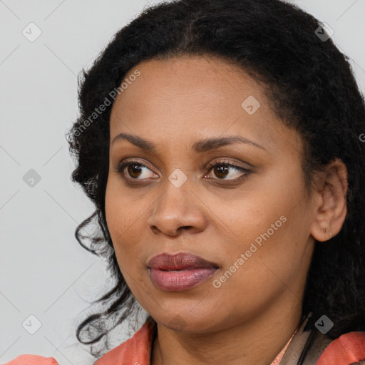 Joyful black young-adult female with long  black hair and brown eyes