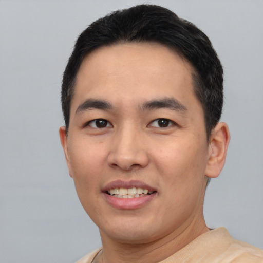 Joyful asian young-adult male with short  black hair and brown eyes