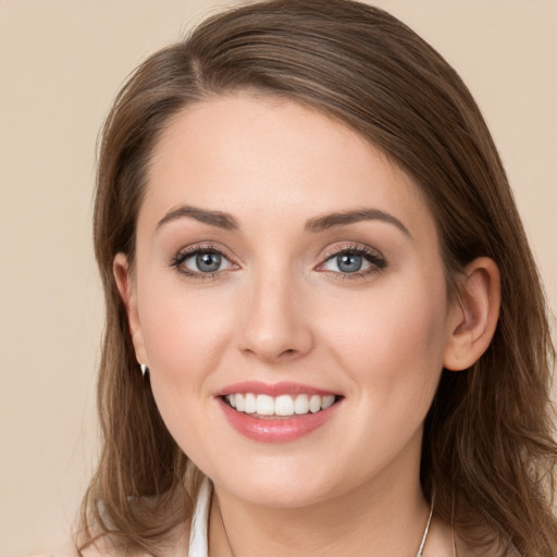 Joyful white young-adult female with long  brown hair and grey eyes