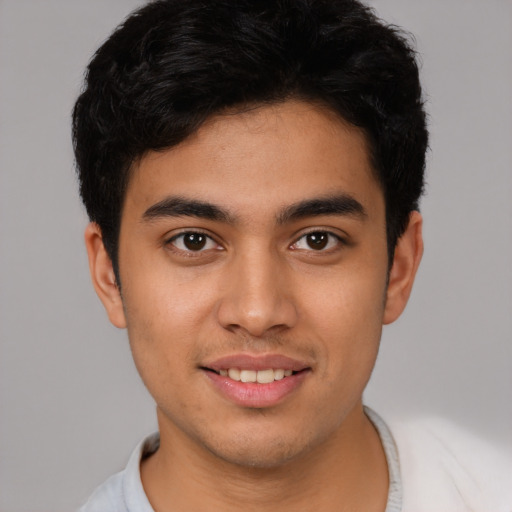 Joyful latino young-adult male with short  brown hair and brown eyes