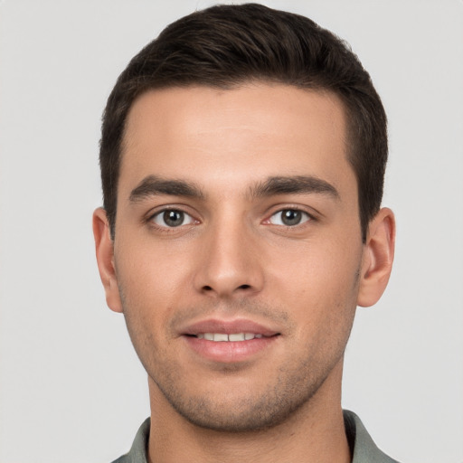 Joyful white young-adult male with short  brown hair and brown eyes