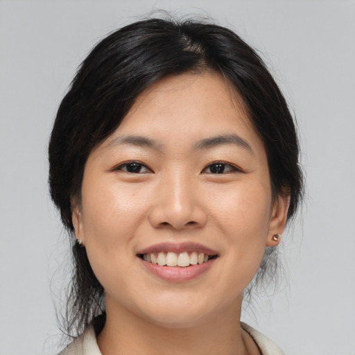 Joyful asian young-adult female with medium  brown hair and brown eyes