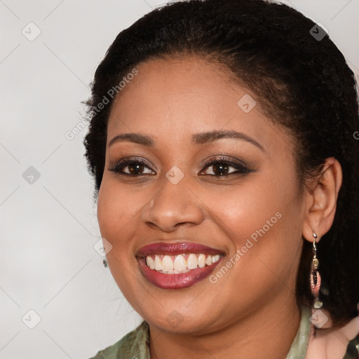 Joyful black young-adult female with long  brown hair and brown eyes