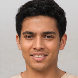 Joyful latino young-adult male with short  brown hair and brown eyes