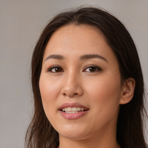 Joyful asian young-adult female with long  brown hair and brown eyes