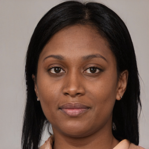 Joyful black young-adult female with long  brown hair and brown eyes