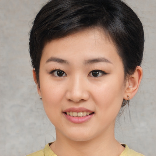 Joyful asian young-adult female with short  brown hair and brown eyes
