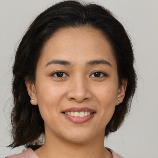 Joyful latino young-adult female with medium  brown hair and brown eyes