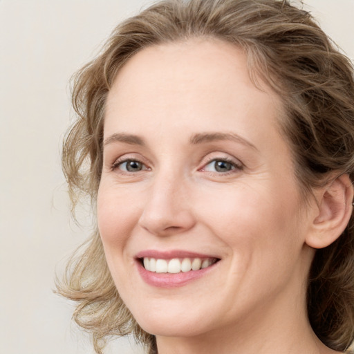 Joyful white young-adult female with medium  brown hair and blue eyes