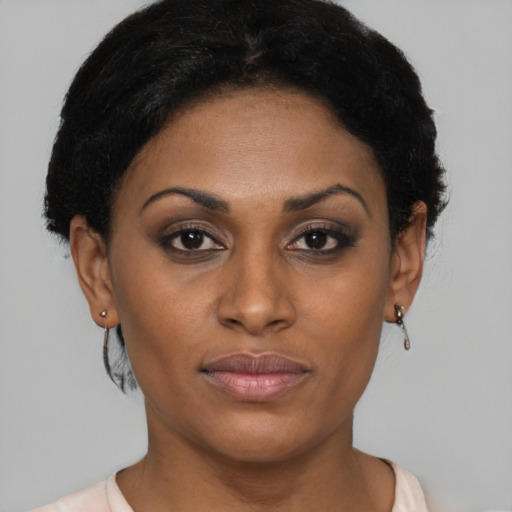 Joyful black young-adult female with short  brown hair and brown eyes